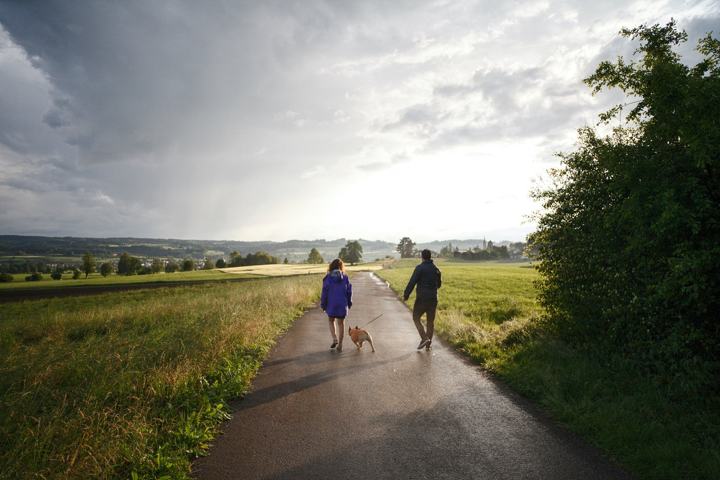 2 people walking with dog