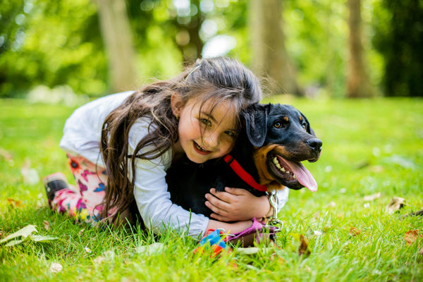 little girl hugging a dog